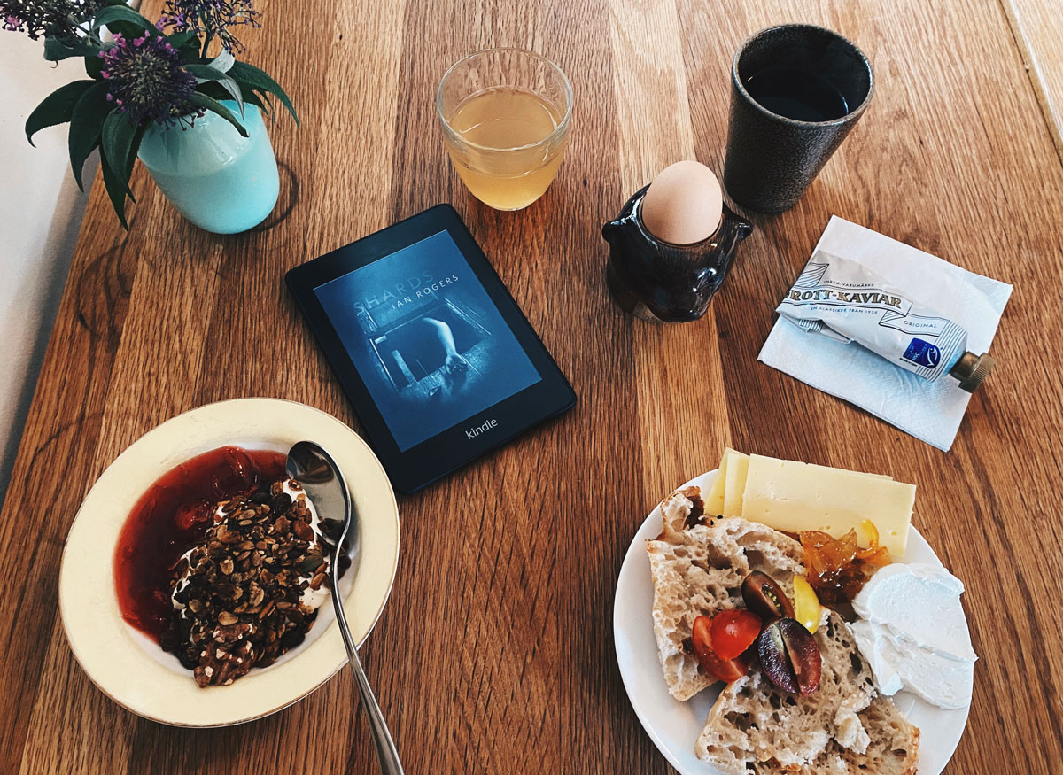 Boken Shards på en Kindle vid ett frukostbord.